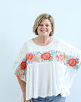 White flowy blouse with floral embroidery from Favored And Common