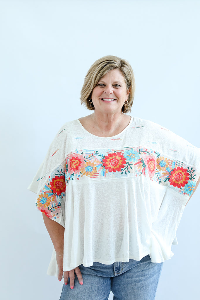 White flowy blouse with floral embroidery from Favored And Common