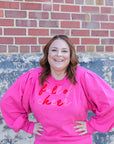 Hot pink Christmas sweatshirt with chenille lettering from Favored And Common in NC