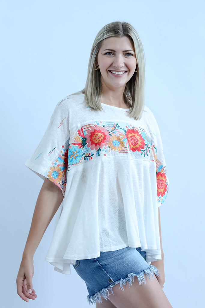 White flowy embroidered blouse with side slits from Favored And Common