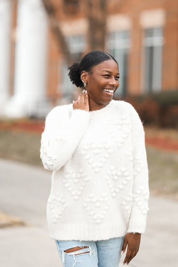 White fuzzy knit sweater with pom pom hearts from Favored And Common