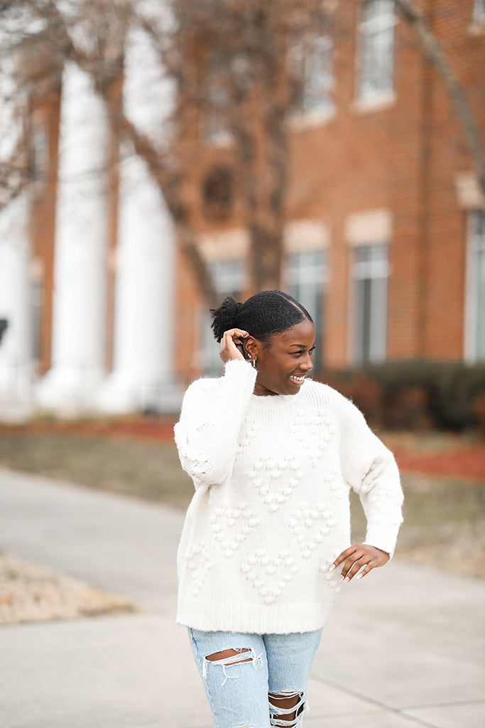 White sweater with pom pom hearts from Favored And Common