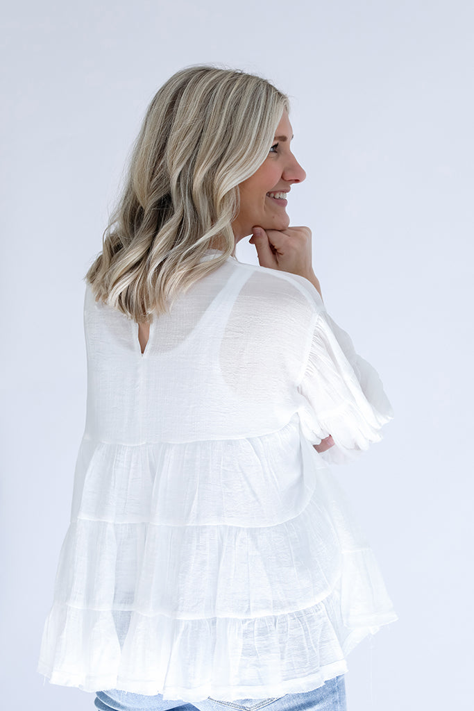 White flowy blouse with key hole back and raw hem from Favored And Common